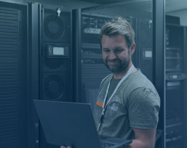 Technician in server room using a laptop