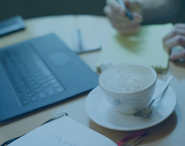 Laptop and coffee cup on a wooden table