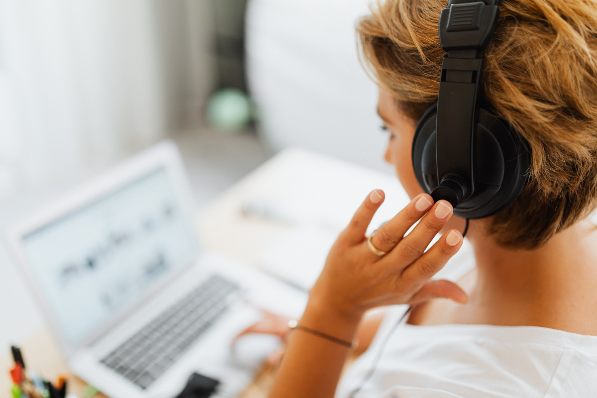 Woman with headphones working on laptop